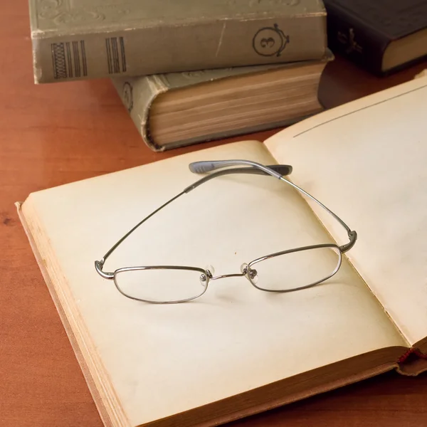 Livros antigos abertos com óculos — Fotografia de Stock