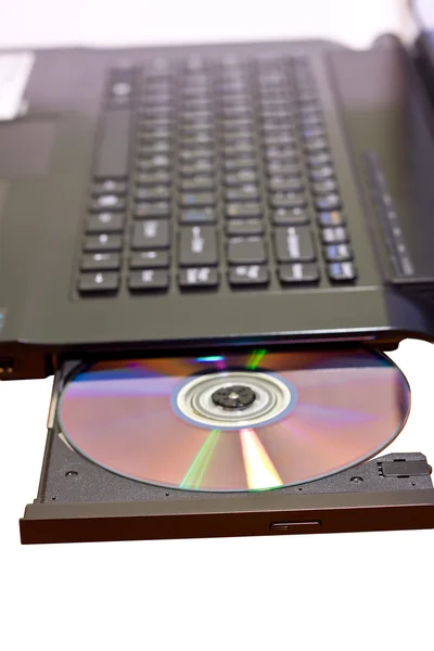 Immagine ravvicinata di un computer portatile e di un disco CD / DVD — Foto Stock