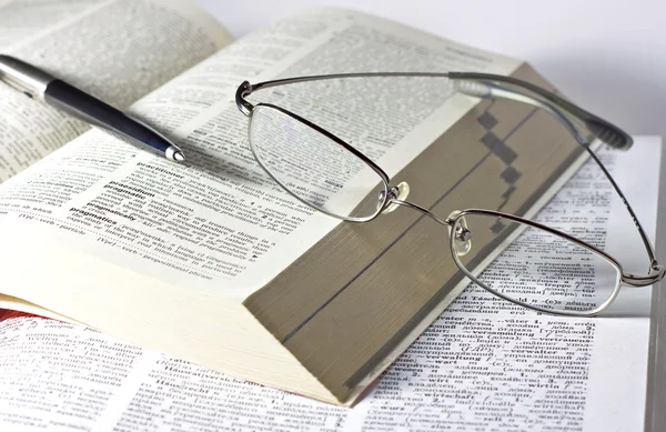 Açık kitap, kalem ve gözlük — Stok fotoğraf