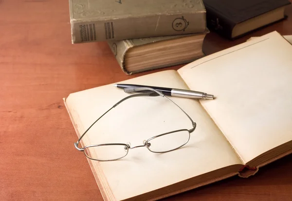 Geopende boek, pen en glazen — Stockfoto