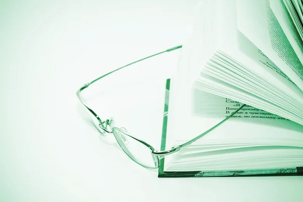 Closeup of opened book and glasses — Stock Photo, Image