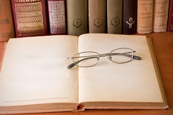 Óculos e livros na biblioteca — Fotografia de Stock