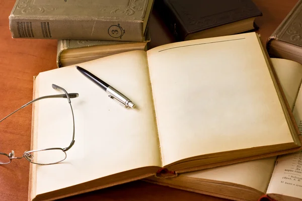 Scrivania con libri, bicchieri e penna — Foto Stock
