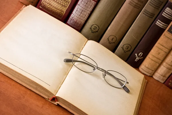 Abrir livro antigo com óculos — Fotografia de Stock
