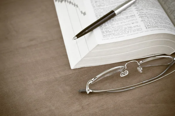 Libro abierto con gafas y bolígrafo —  Fotos de Stock
