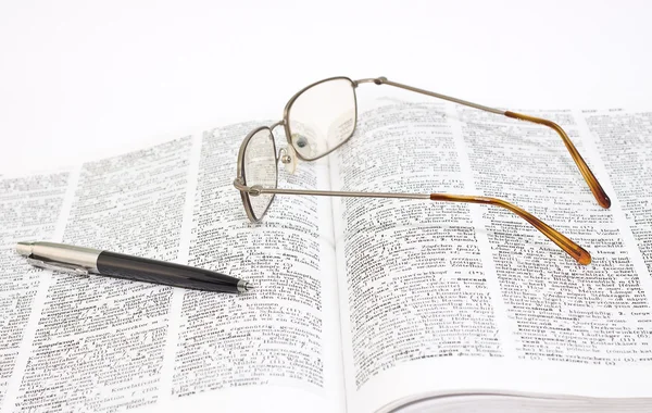 Gros plan du livre ouvert, des lunettes et du stylo — Photo