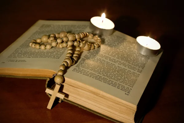 Деревянный крест над библией со свечами — стоковое фото