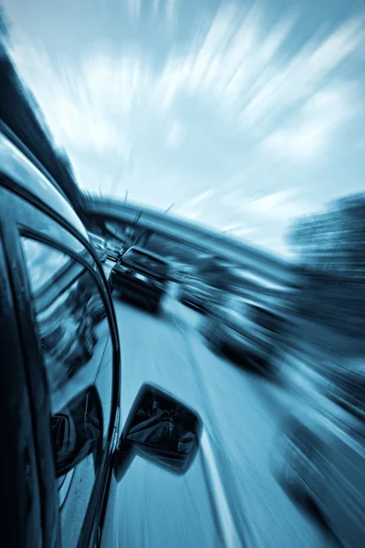 Carro dirigindo rápido com fundo embaçado — Fotografia de Stock