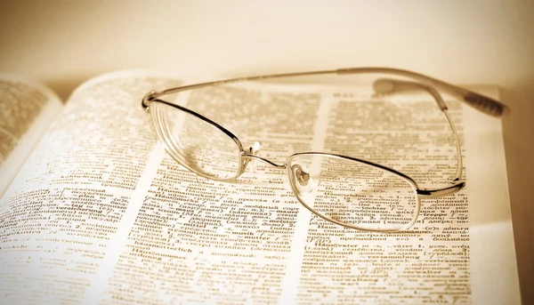 Óculos em livro aberto — Fotografia de Stock