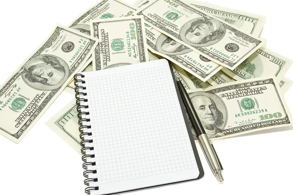 Спиральный ноутбук и ручка на долларовом фоне — стоковое фото