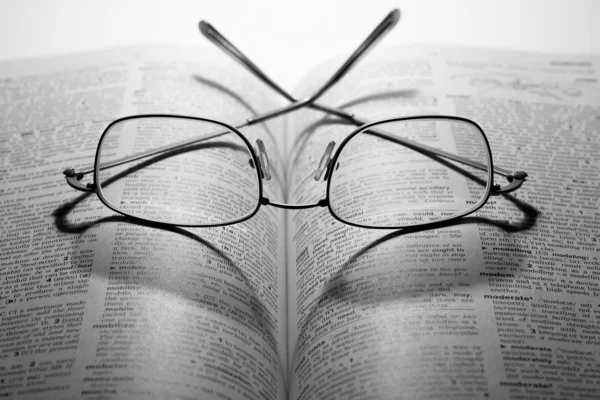 Açık bir kitapta gözlük okumak — Stok fotoğraf