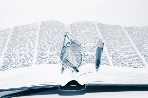 Óculos no livro com caneta — Fotografia de Stock