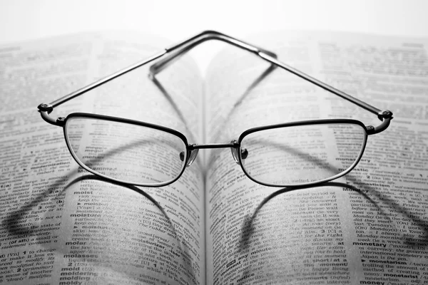 Leesbrillen op een woordenboek — Stockfoto