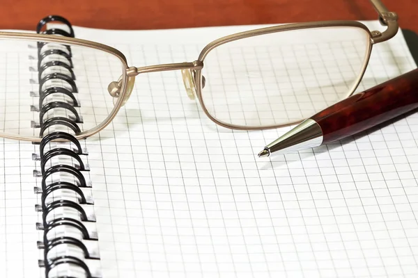 Notepad with eyeglasses and pen — Stock Photo, Image