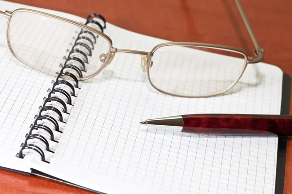 Óculos, bloco de notas com caneta — Fotografia de Stock