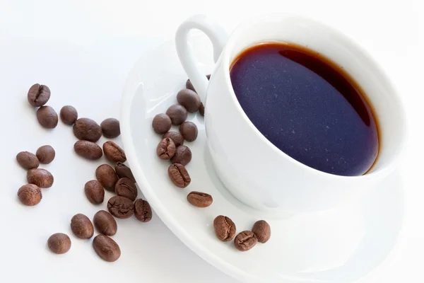 Kopp med kaffe och kaffebönor — Stockfoto