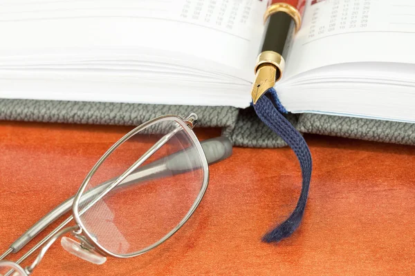 Pen, a szemüveg és a notebook — Stock Fotó