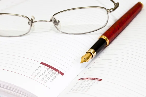 Bolígrafo, gafas, cuaderno . — Foto de Stock