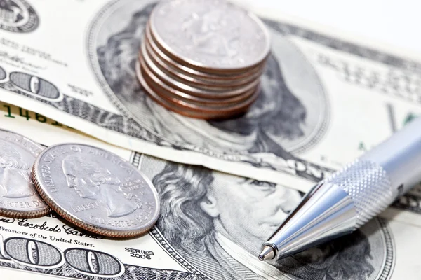 Close-up pen op de dollars en munten — Stockfoto