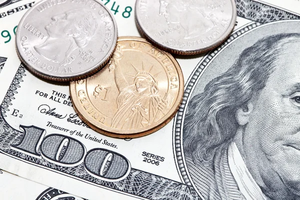 Coins over hundred dollar bills background — Stock Photo, Image