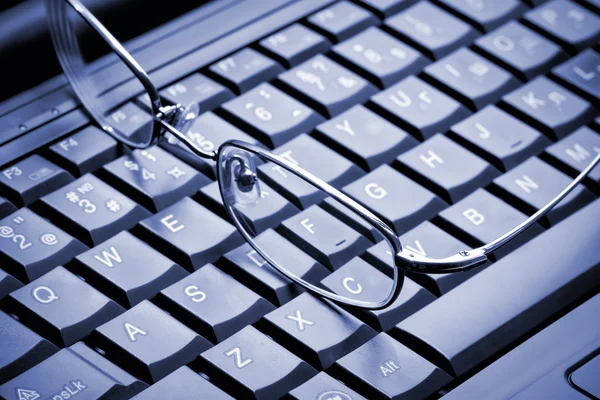 Glasses lying on the laptop — Stock Photo, Image