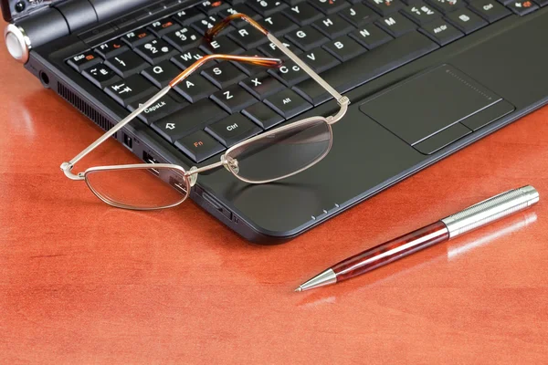 Dizüstü bilgisayar, kalem ve gözlük — Stok fotoğraf