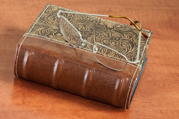Старомодная винтажная книга с очками — стоковое фото