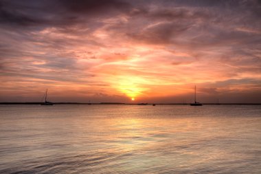 Sailing boat silhouette over sunset sky clipart