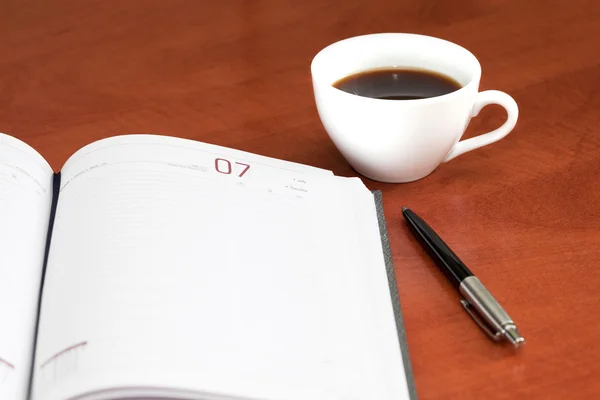 Kaffeetasse, Notizbuch und Stift — Stockfoto