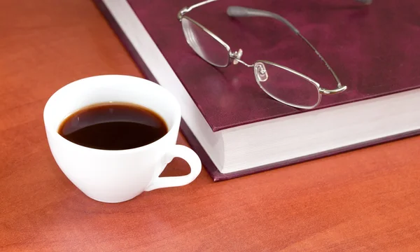 Šálek kávy s knihou a brýle — Stock fotografie