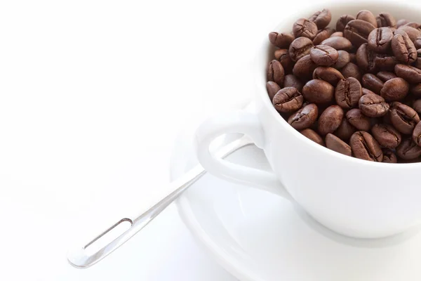Белая чашка с кофейными зернами — стоковое фото