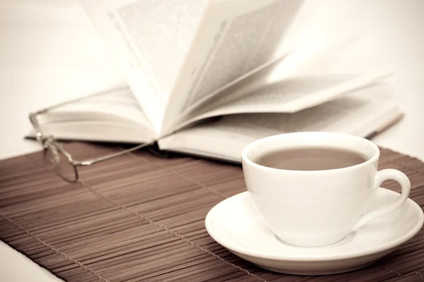 Retro afbeelding van een witte kop van koffie en boek met glazen — Stockfoto