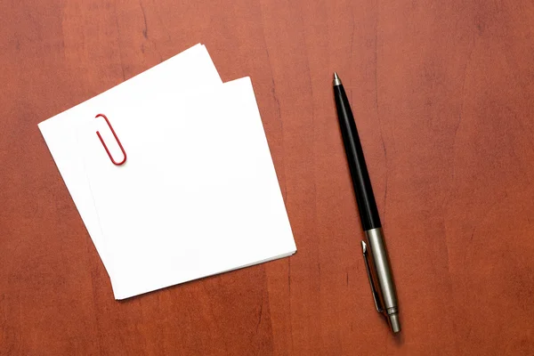 Белая бумага с зажимом и ручкой — стоковое фото