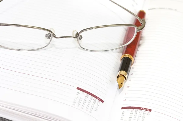 Denní Plánovač s brýlemi a pera — Stock fotografie