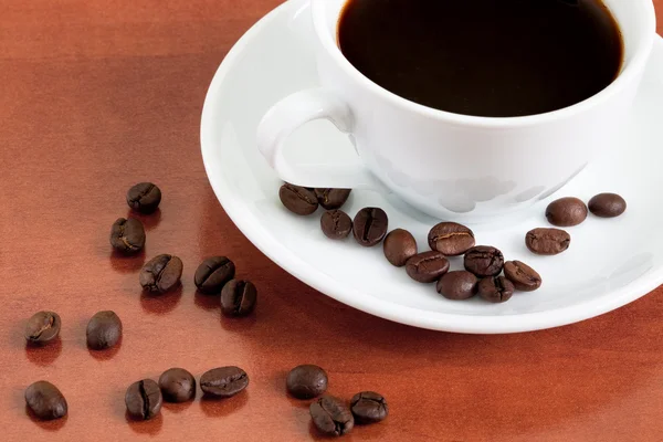 Vit kopp med kaffebönor — Stockfoto