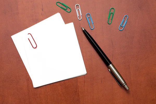 Nota de papel branco com um clipe e caneta — Fotografia de Stock