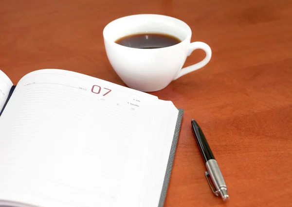 Taza de café, cuaderno y pluma — Foto de Stock