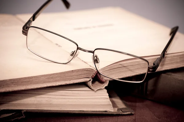Bok och glasögon i biblioteket — Stockfoto