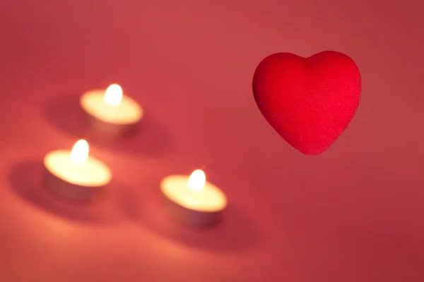Красное сердце с горящими свечами — стоковое фото