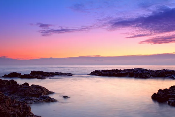 Kleurrijke zonsopgang aan de rotskust — Stockfoto