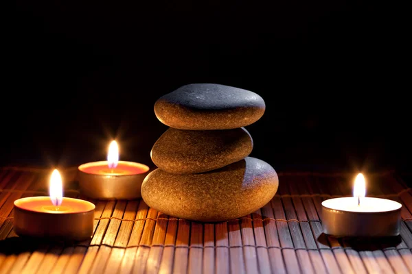 Burning candles and and a stack of pebbles — Stock Photo, Image