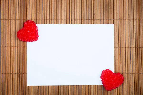 Zwei rote Herzen mit Papierkarte — Stockfoto