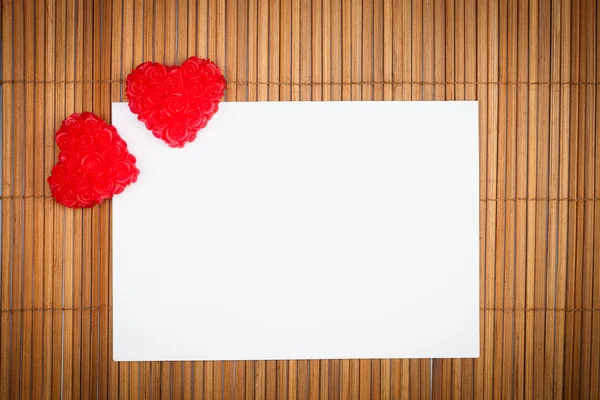 Два красных сердца с бумажной картой — стоковое фото