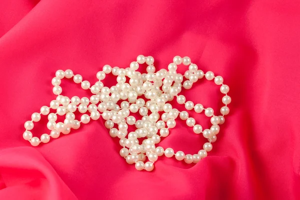 Pearl necklace on red silk — Stock Photo, Image