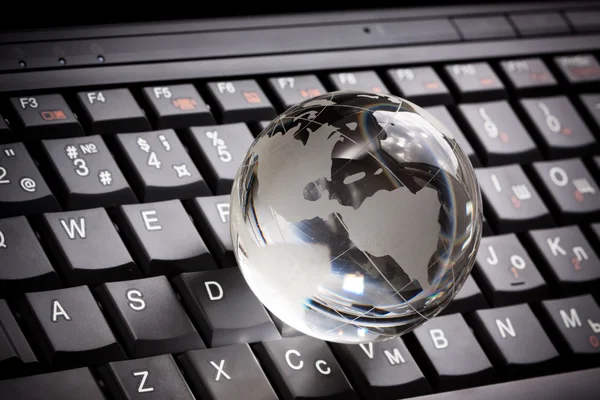 Globo de cristal no teclado laptop — Fotografia de Stock