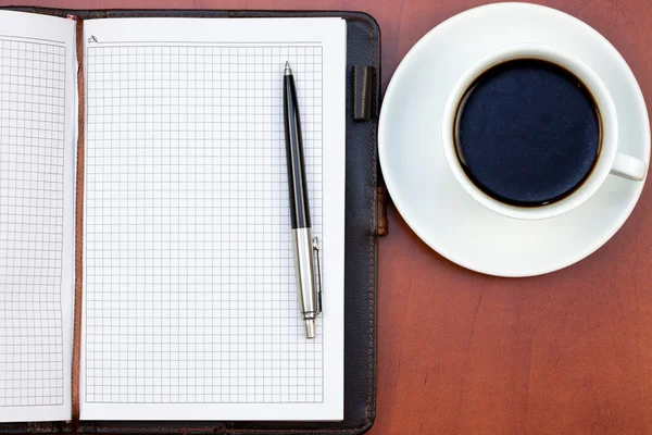 Kaffekopp, anteckningsbok och penna — Stockfoto
