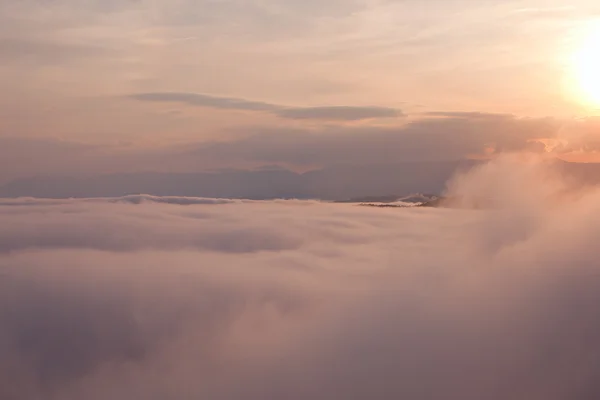 Pôr do sol sobre montanhas nubladas — Fotografia de Stock