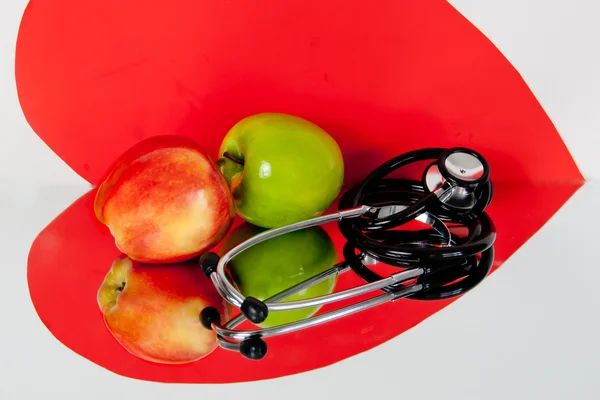 Два яблока, сердце и стетоскоп — стоковое фото