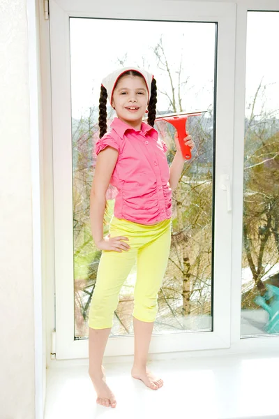 stock image Girl with squeegee stands on a windowsill