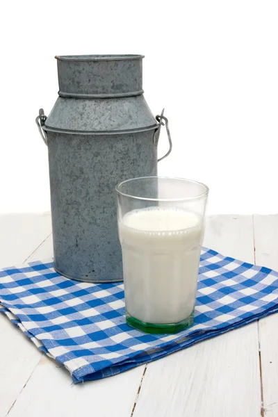 Lattine e bicchiere di latte sul tavolo di legno — Foto Stock